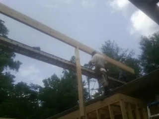 Carpenter setting a ridge beam over a new addition frame — Ice Dam Removal by Roofing Brothers in Dell