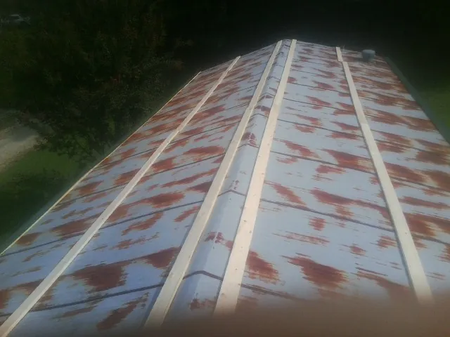 Rusted metal roof panels with new wood purlins before replacement — Storm Damage Roof Repair in Dell by Roofing Brothers
